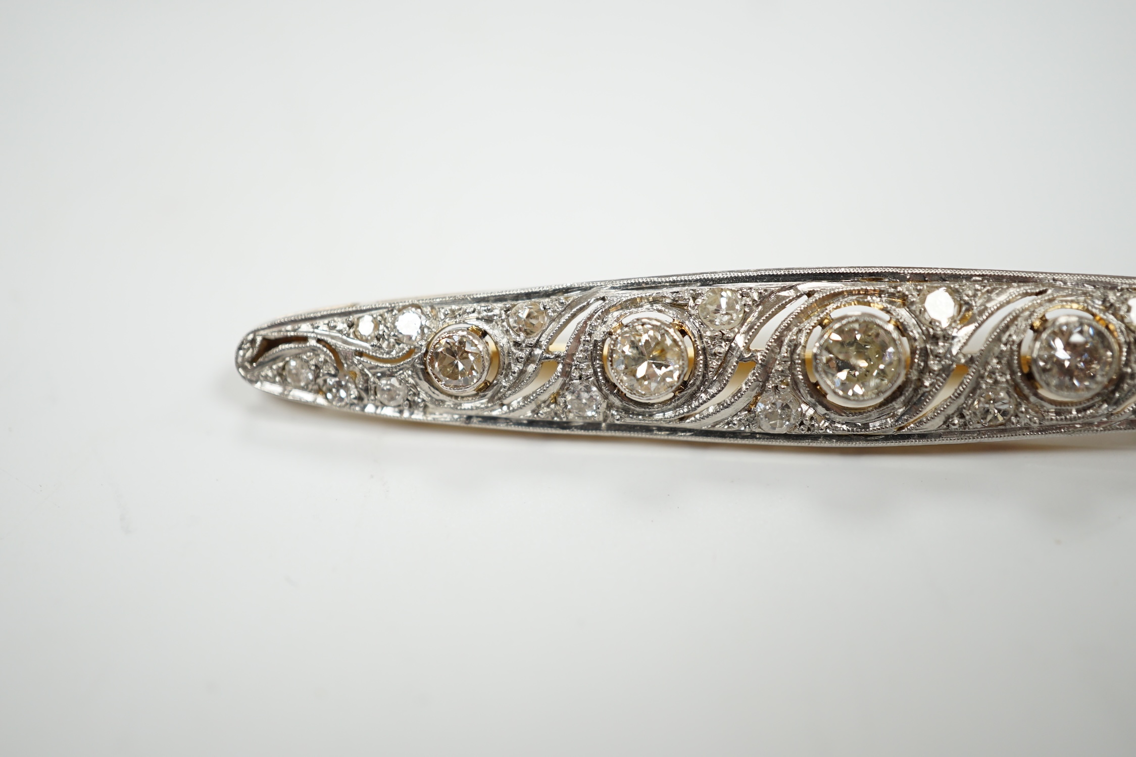 A Belle Epoque pierced white and yellow metal, diamond cluster set navette shaped bar brooch, 62mm, gross weight 5.5 grams.